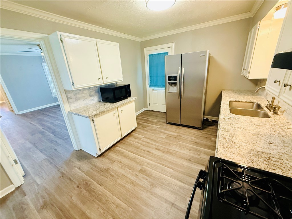 1413 Burt Street Bryan, TX 77802 - Photo 8 of 19 a kitchen with stainless steel appliances a refrigerator a sink a stove and white cabinets