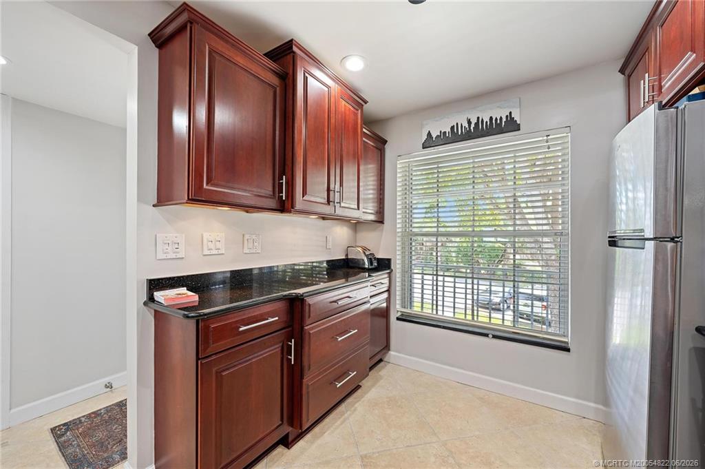 1862 Southwest Palm City Road, Unit 203 Stuart, FL 34994 - Photo 6 of 39 a kitchen with stainless steel appliances granite countertop cabinets and window