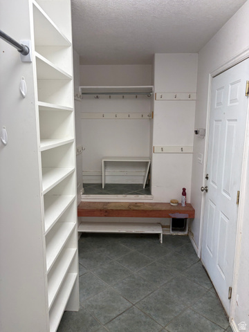 587 West 2400 South Perry, UT 84302 - Photo 17 of 46 Entryway featuring a white paneled door, built-in shelving, storage hooks, and square tile flooring