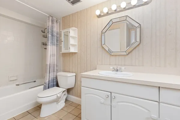 a bathroom with a toilet a sink a mirror and bathtub
