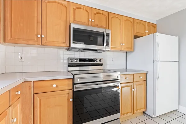 a kitchen with stainless steel appliances granite countertop a refrigerator stove and microwave
