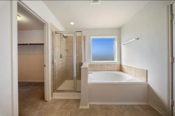 a spacious bathroom with a tub shower and sink