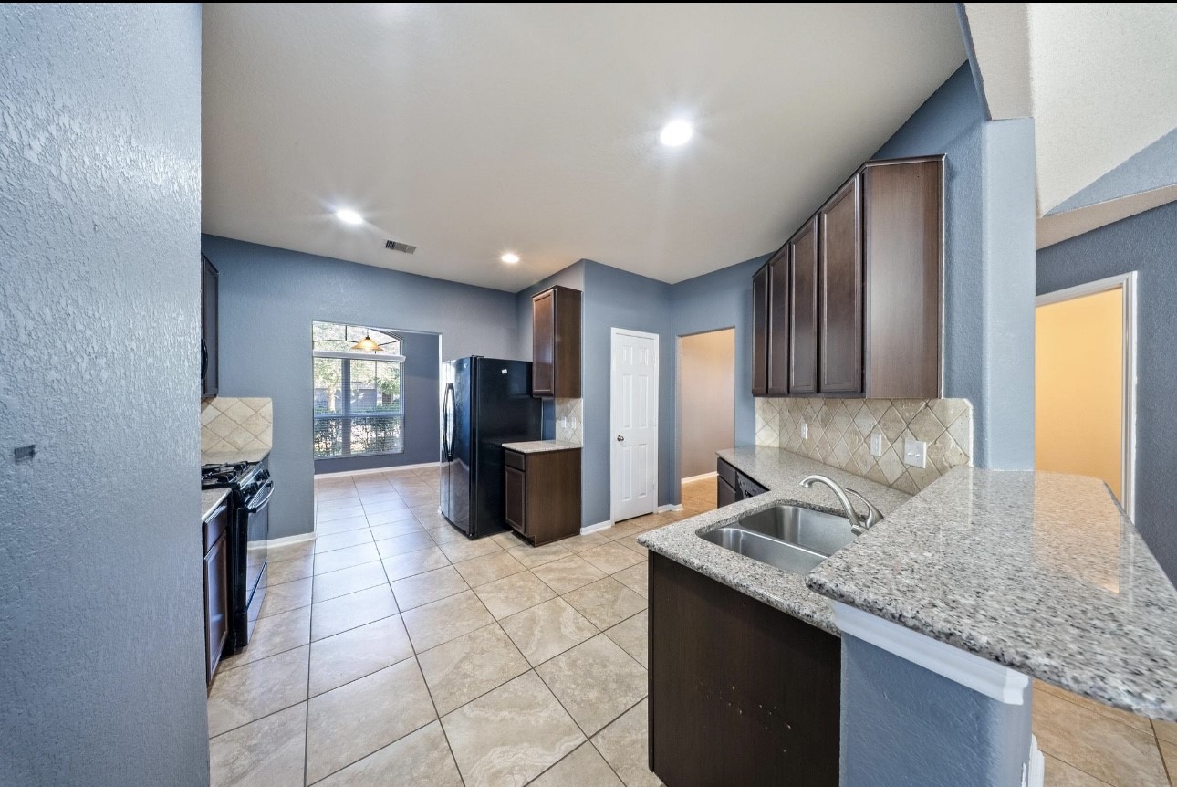 15003 Signal Ridge Way Cypress, TX 77429 - Photo 5 of 21 a kitchen with stainless steel appliances granite countertop a sink stove and cabinets