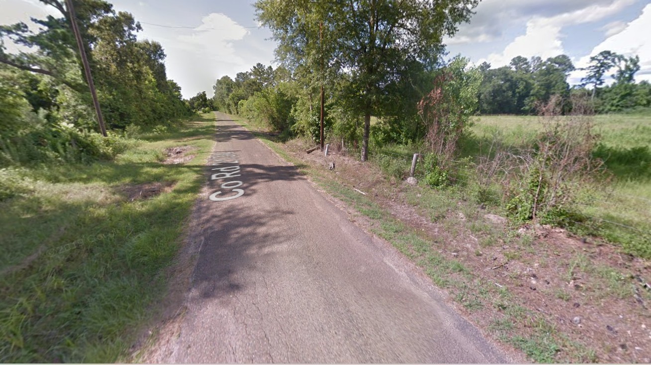 2715 County Road 2134 Cleveland, TX 77327 - Photo 5 of 8 a view of a dirt road with trees in the background