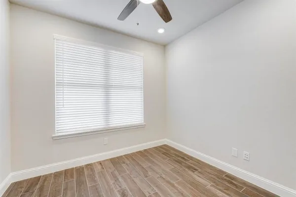 an empty room with a window and wooden floor