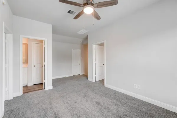 an empty room with chandelier fan