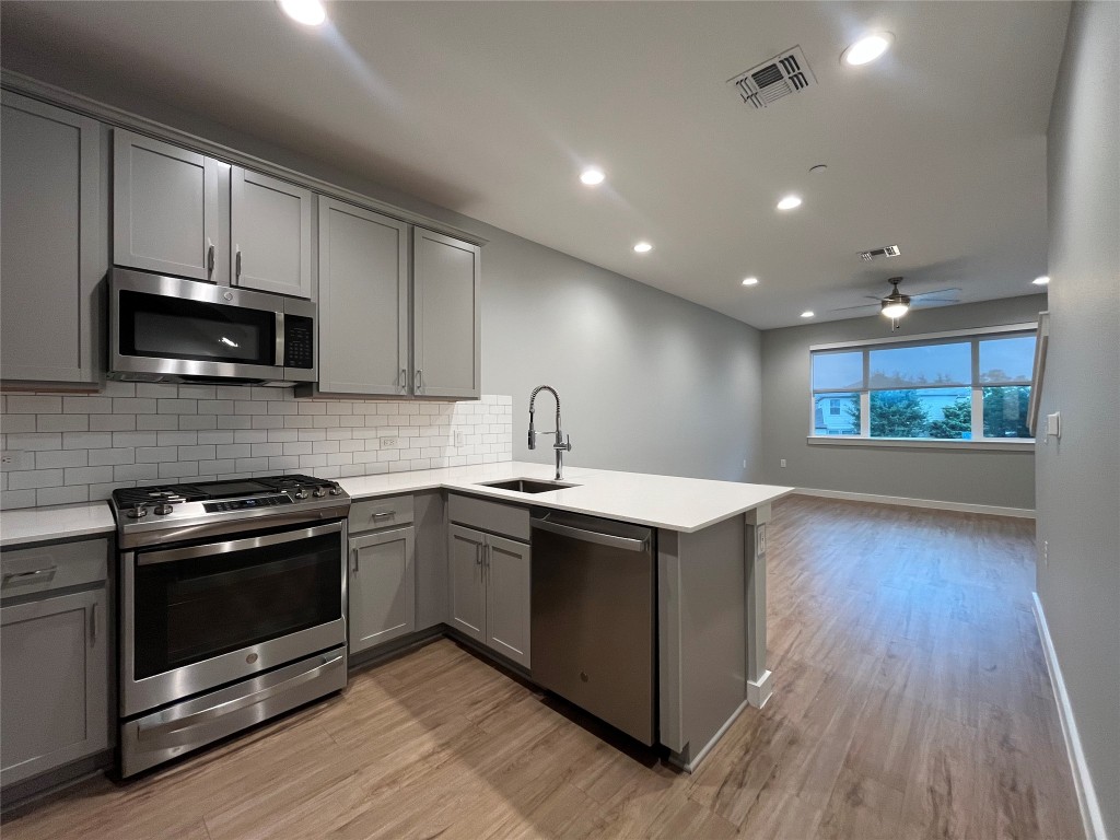 11402 Pastini Circle Manchaca, TX 78652 - Photo 7 of 21 a kitchen with stainless steel appliances wooden floor sink and wooden cabinets