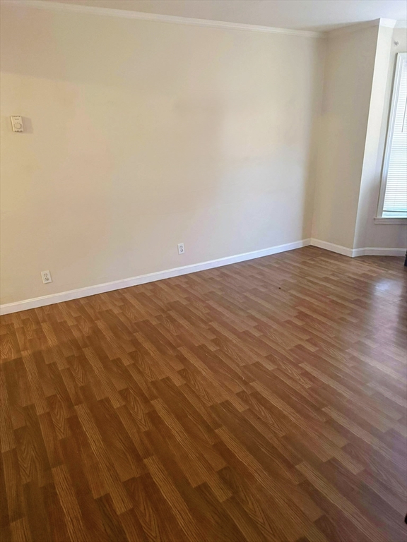 101 West Hollis Street, Unit 1 Nashua, NH 03060 - Photo 5 of 6 a view of an empty room with wooden floor and a window