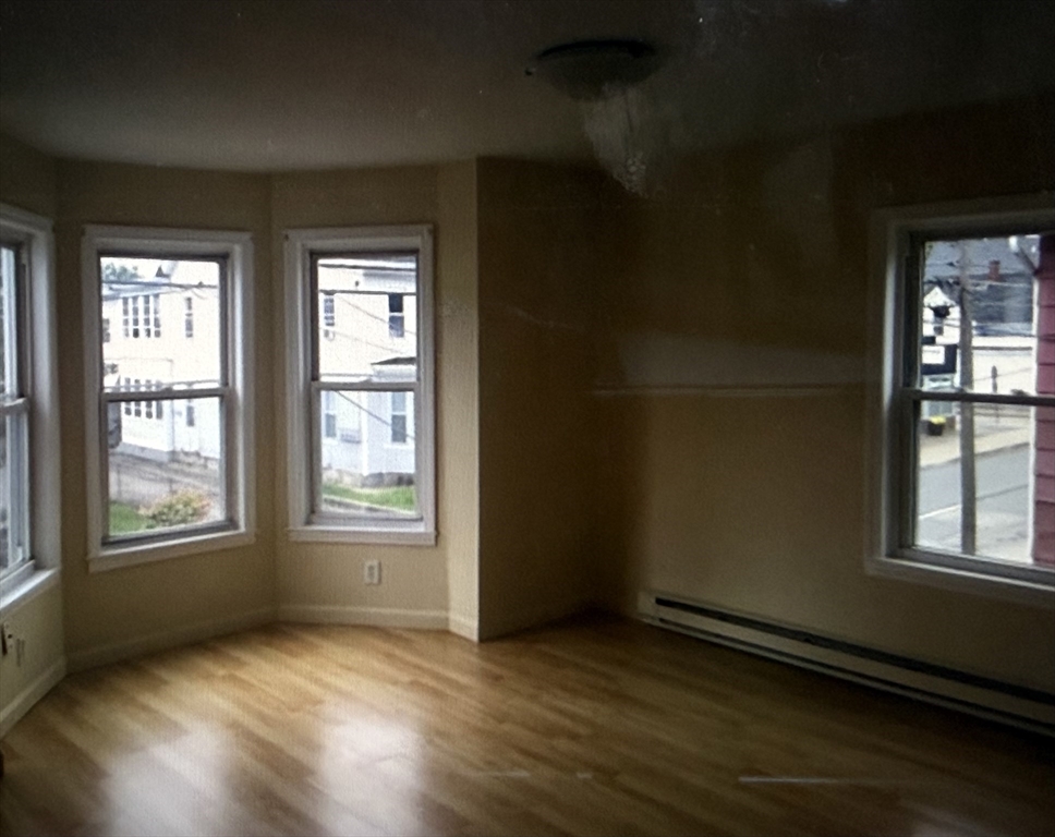 101 West Hollis Street, Unit 1 Nashua, NH 03060 - Photo 6 of 6 an empty room with wooden floor and windows