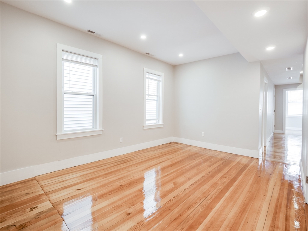 232 Saratoga Street, Unit 2 Boston, MA 02128 - Photo 2 of 9 a view of empty room with wooden floor and fan