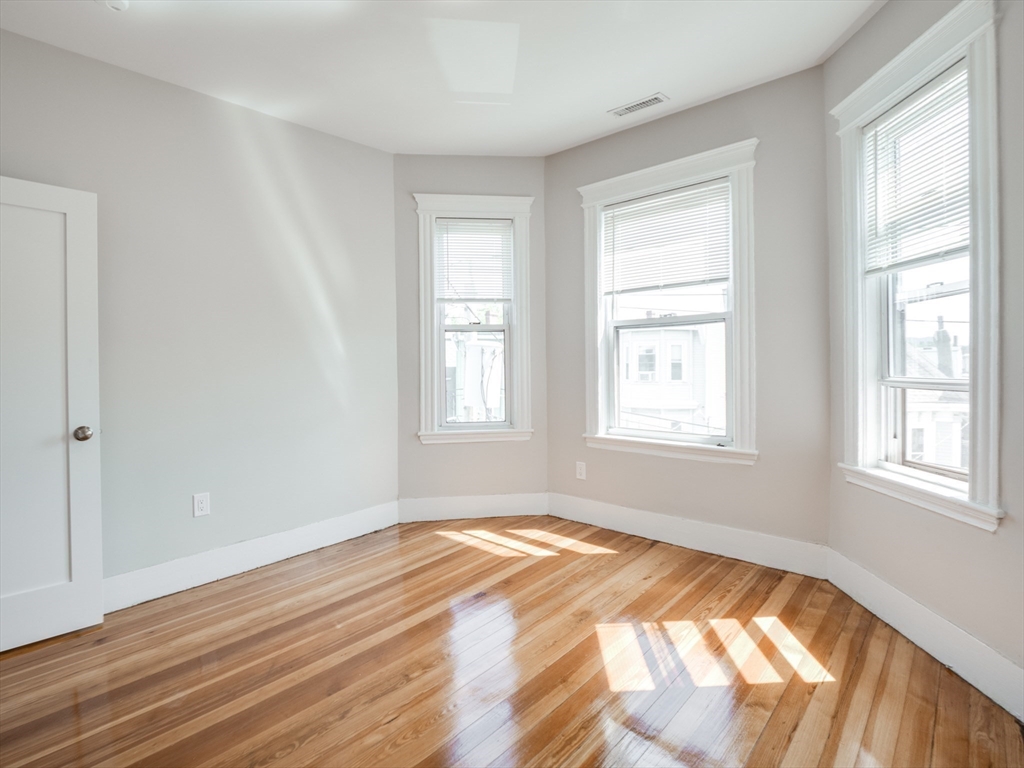 232 Saratoga Street, Unit 2 Boston, MA 02128 - Photo 8 of 9 a view of empty room with wooden floor and fan