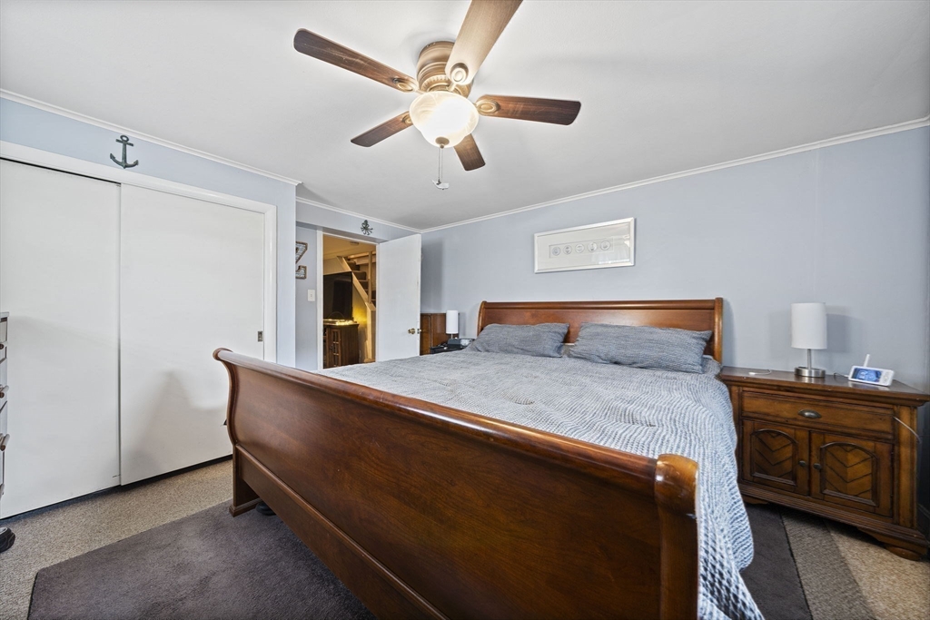 15 D Street Hull, MA 02045 - Photo 18 of 42 a bedroom with a bed and a chandelier