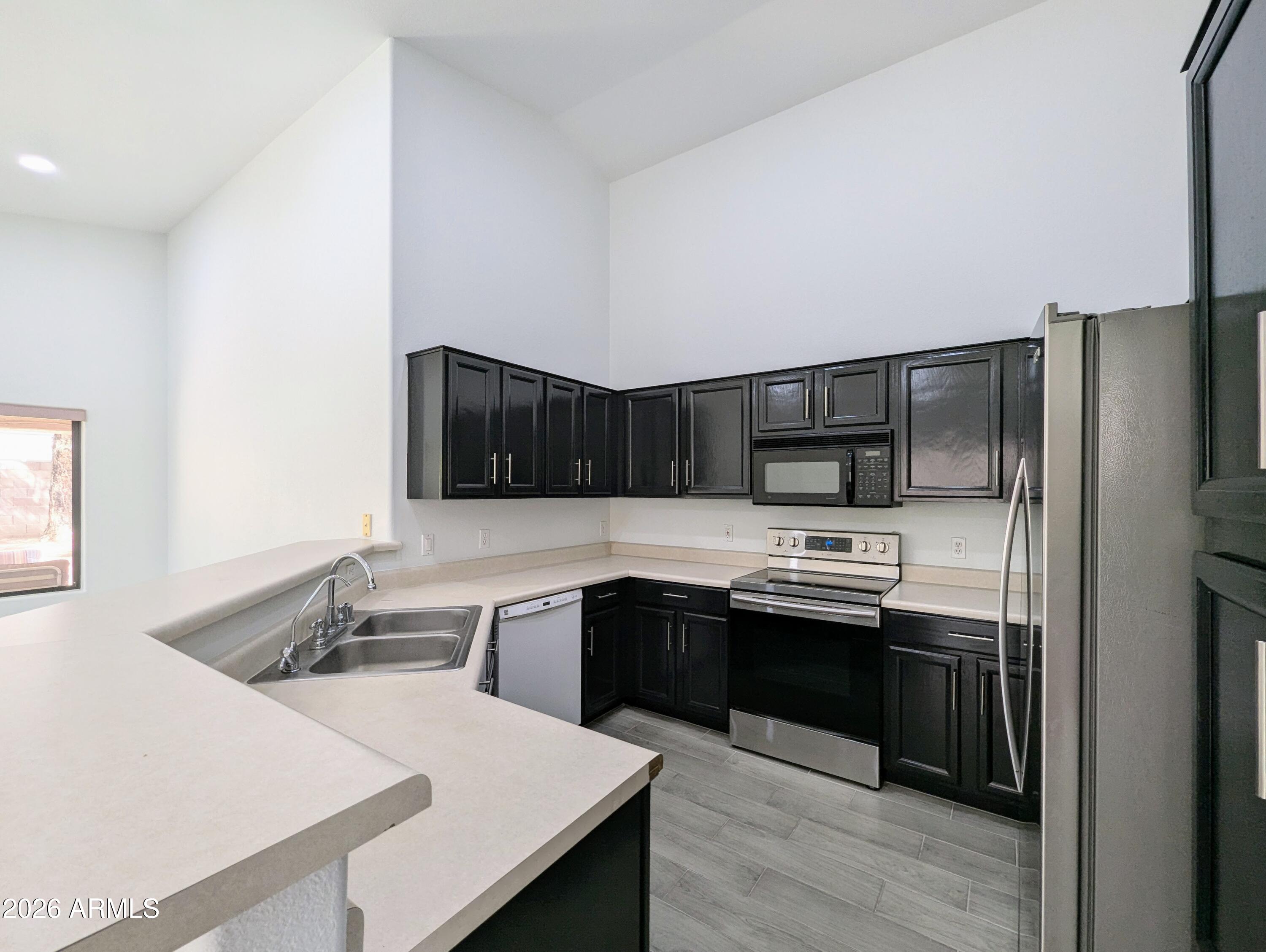 5424 West Wagoner Road Glendale, AZ 85308 - Photo 12 of 37 a kitchen with stainless steel appliances granite countertop a sink stove and refrigerator