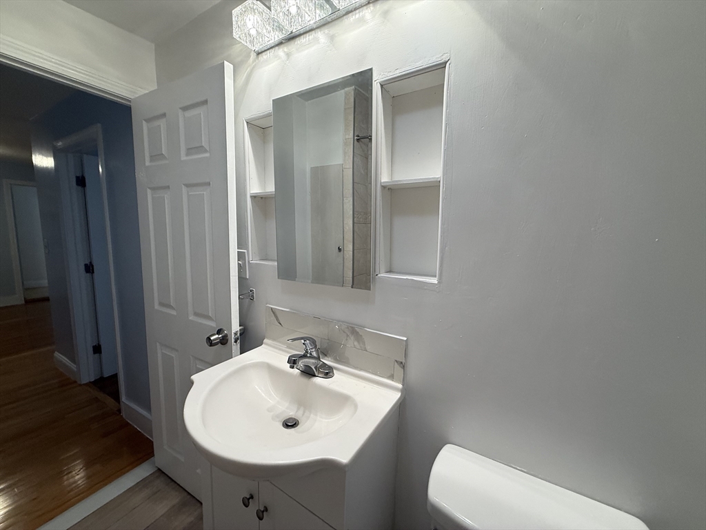23 Myrtle Street, Unit 2 Quincy, MA 02171 - Photo 8 of 12 a bathroom with a sink a toilet and mirror