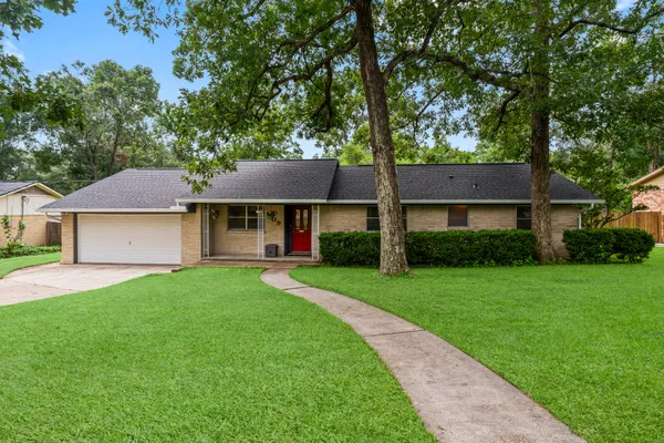 a front view of a house with a yard and trees