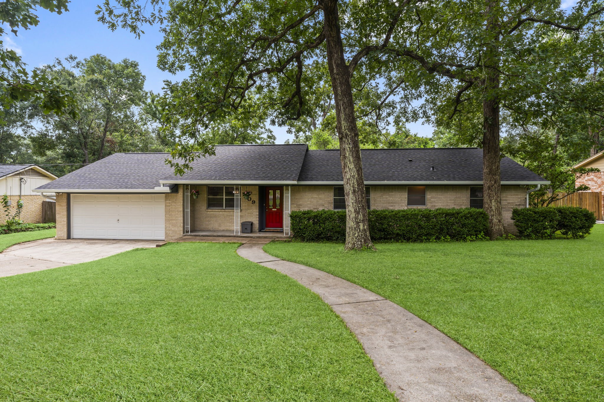 a front view of a house with a yard and trees