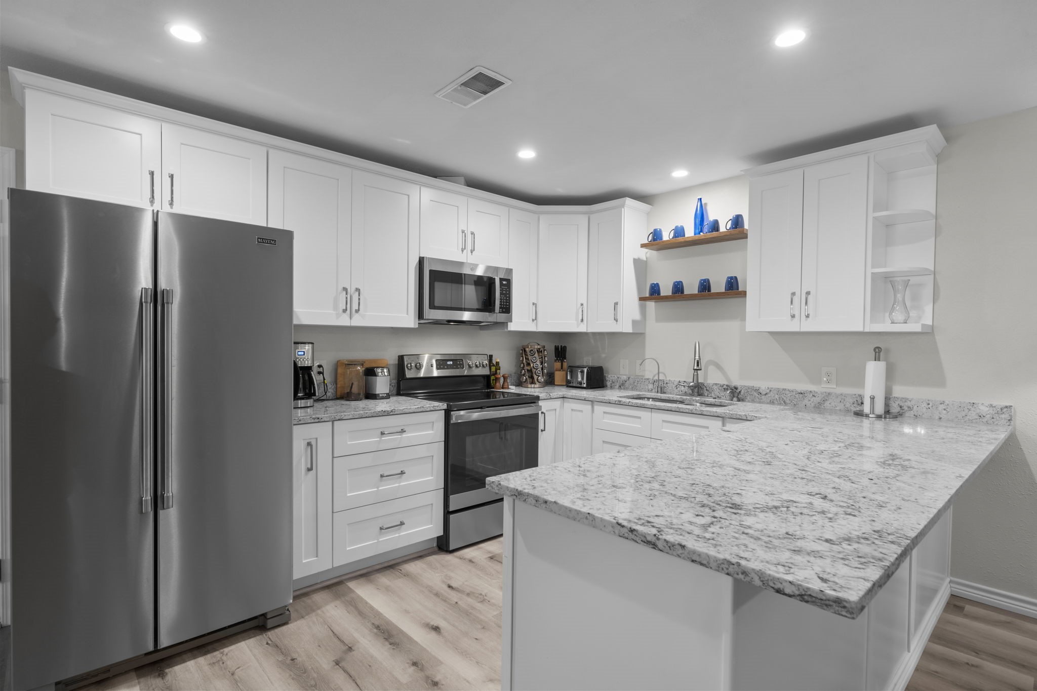 209 Summit Drive Conroe, TX 77303 - Photo 3 of 21 a kitchen with stainless steel appliances granite countertop a refrigerator stove microwave and sink