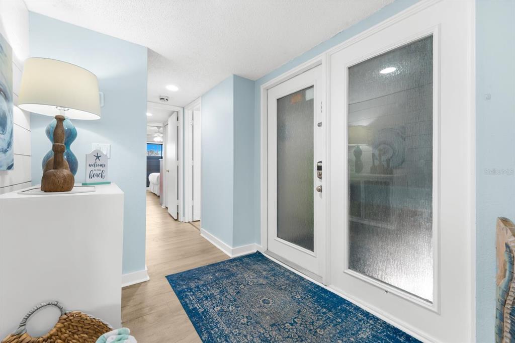 102 68th Street, Unit 102 Holmes Beach, FL 34217 - Photo 12 of 48 a view of a hallway with wooden floor and a living room