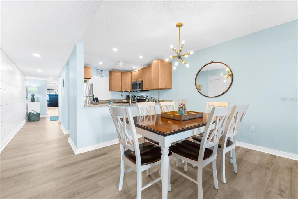 102 68th Street, Unit 102 Holmes Beach, FL 34217 - Photo 27 of 48 a view of a dining room with furniture and wooden floor