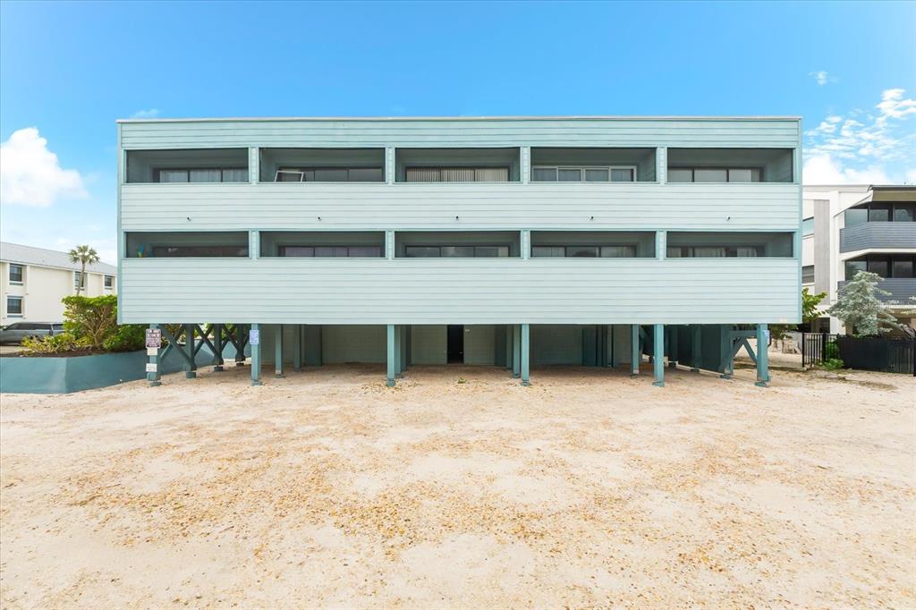 102 68th Street, Unit 102 Holmes Beach, FL 34217 - Photo 4 of 48 a front view of a house with a yard