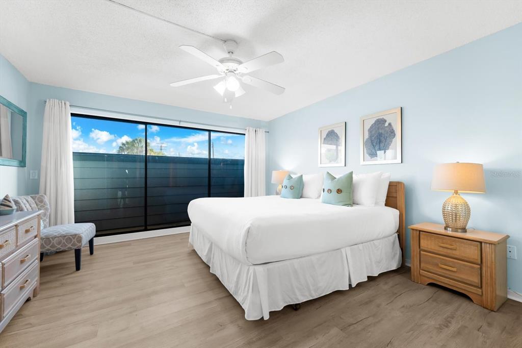 102 68th Street, Unit 102 Holmes Beach, FL 34217 - Photo 6 of 48 a bedroom with a bed and a lamp