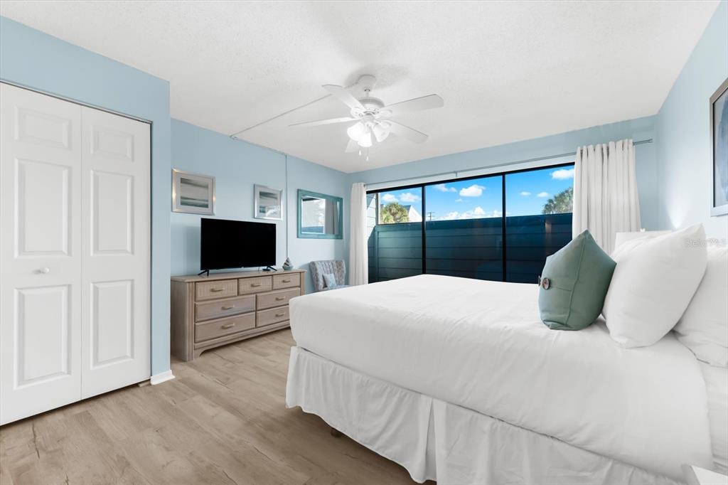 102 68th Street, Unit 102 Holmes Beach, FL 34217 - Photo 7 of 48 a bedroom with a bed and a flat screen tv