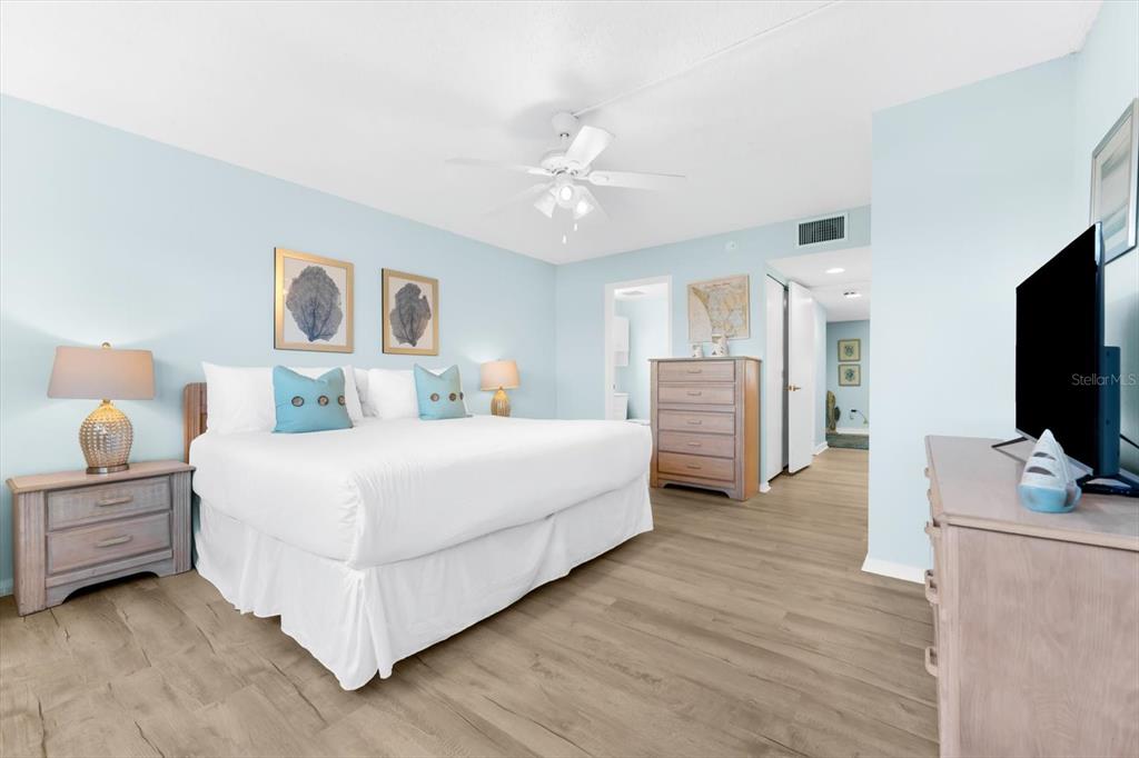 102 68th Street, Unit 102 Holmes Beach, FL 34217 - Photo 8 of 48 a bedroom with a bed and a flat screen tv