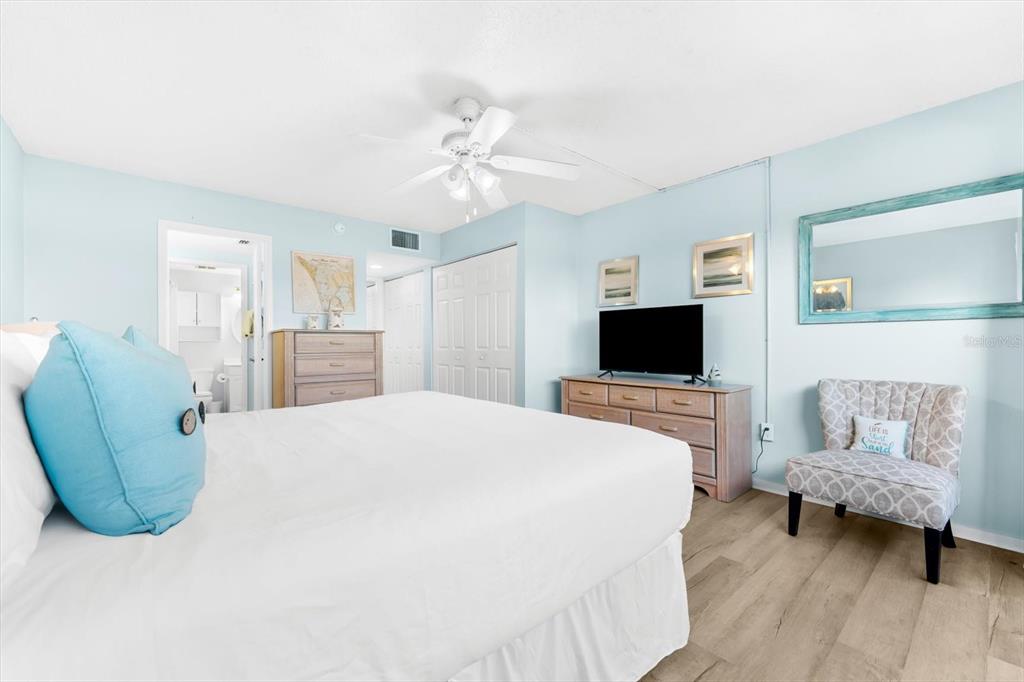 102 68th Street, Unit 102 Holmes Beach, FL 34217 - Photo 9 of 48 a bedroom with a bed a couch and dresser