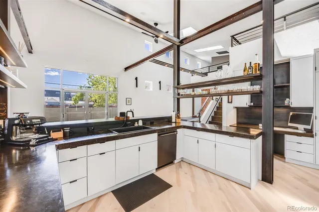 a bathroom with a toilet a sink and wooden floor