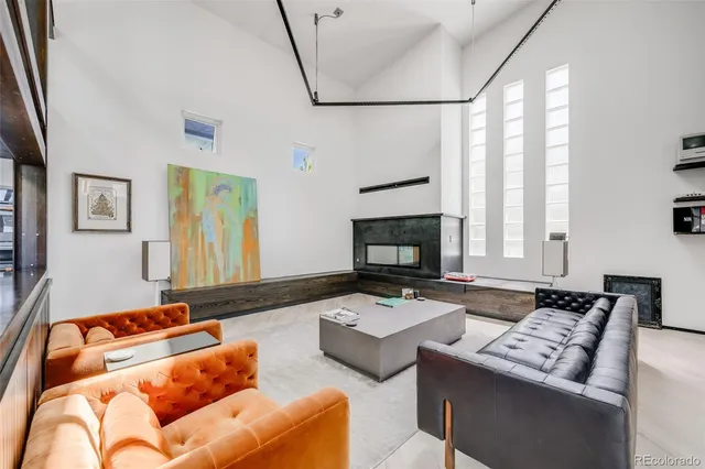 a open kitchen with stainless steel appliances a white table chairs and a wooden floor