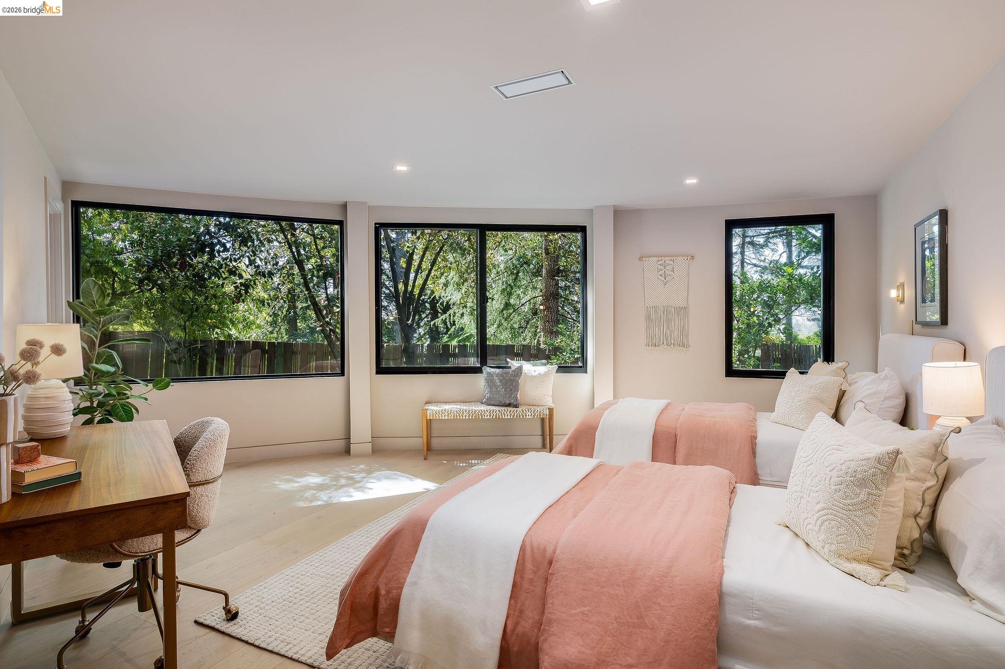 5645 Bacon Road Oakland, CA 94619 - Photo 59 of 94 Spacious bedroom featuring multiple large windows with black framing, wood-finish flooring, recessed lighting, and wall-mounted sconces