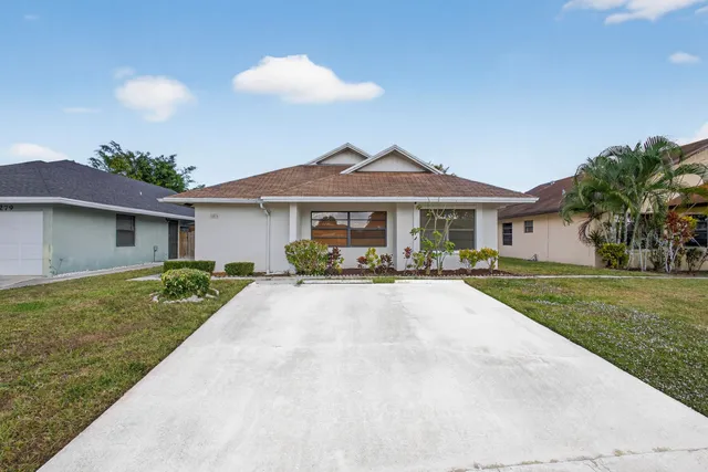a front view of a house with yard patio and green space