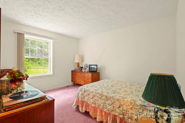 a bedroom with bed and mirror