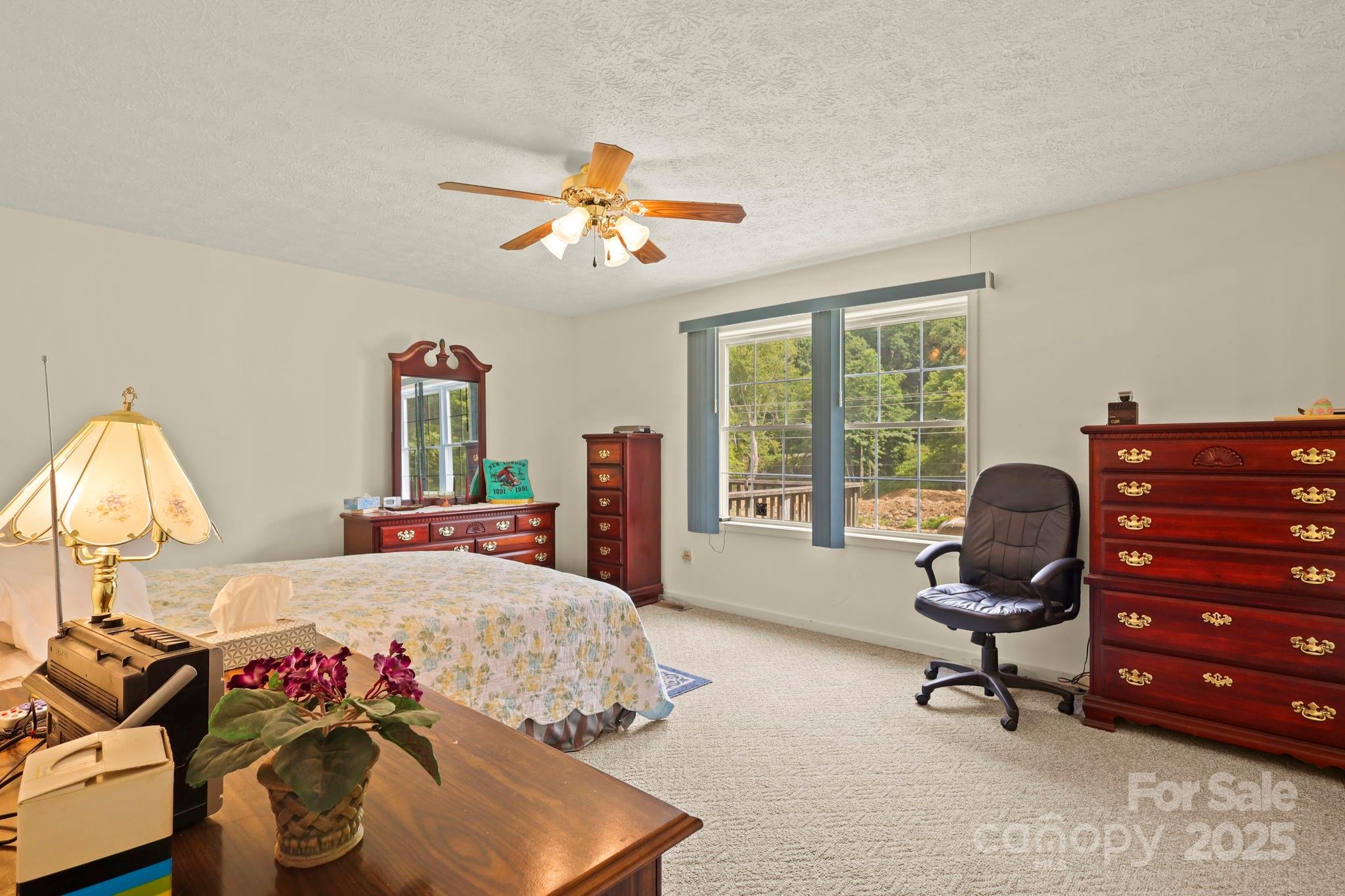 31 Barlow Road Elk Park, NC 28622 - Photo 23 of 40 a bedroom with a bed and a chandelier