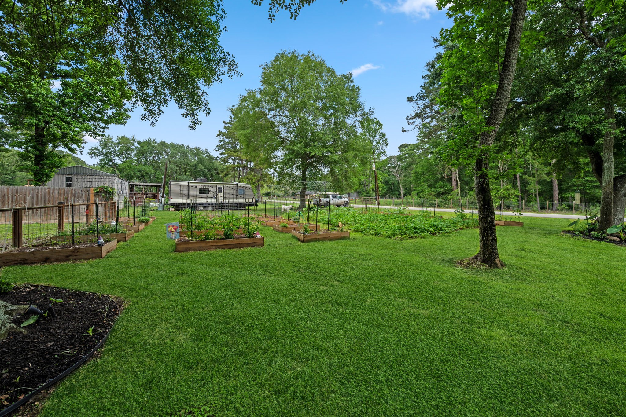18 East Old Field Road Huffman, TX 77336 - Photo 32 of 35 Another scenic perspective of the sprawling one-acre homesite showcases the beautifully established garden, adding charm, character, and a peaceful natural element to the property’s picturesque outdoor setting.