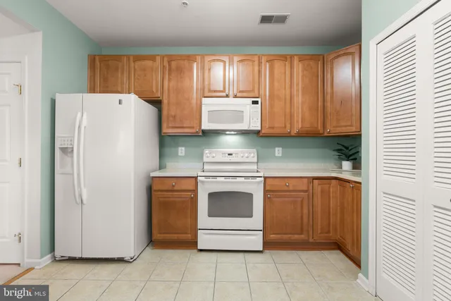 a kitchen with stainless steel appliances granite countertop a refrigerator and a stove