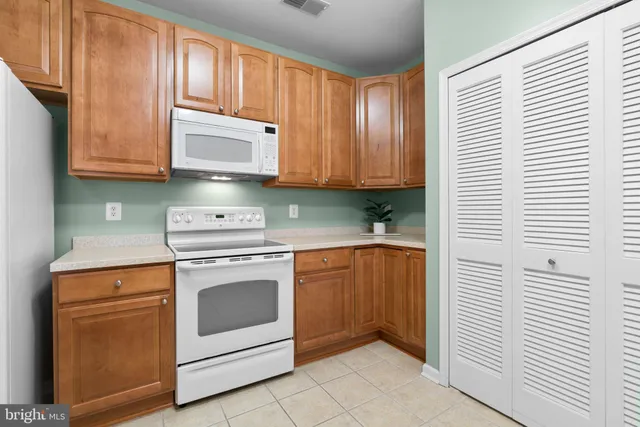 a kitchen with granite countertop white cabinets and white appliances