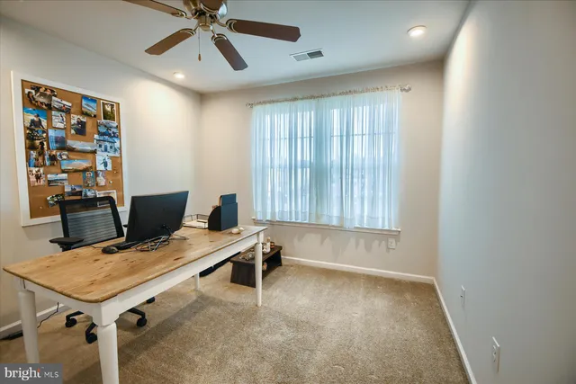 a view of a workspace with furniture and a window