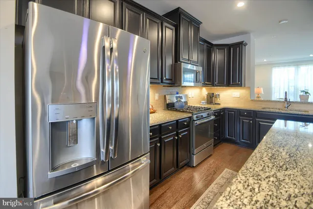 a kitchen with granite countertop stainless steel appliances and wooden cabinets