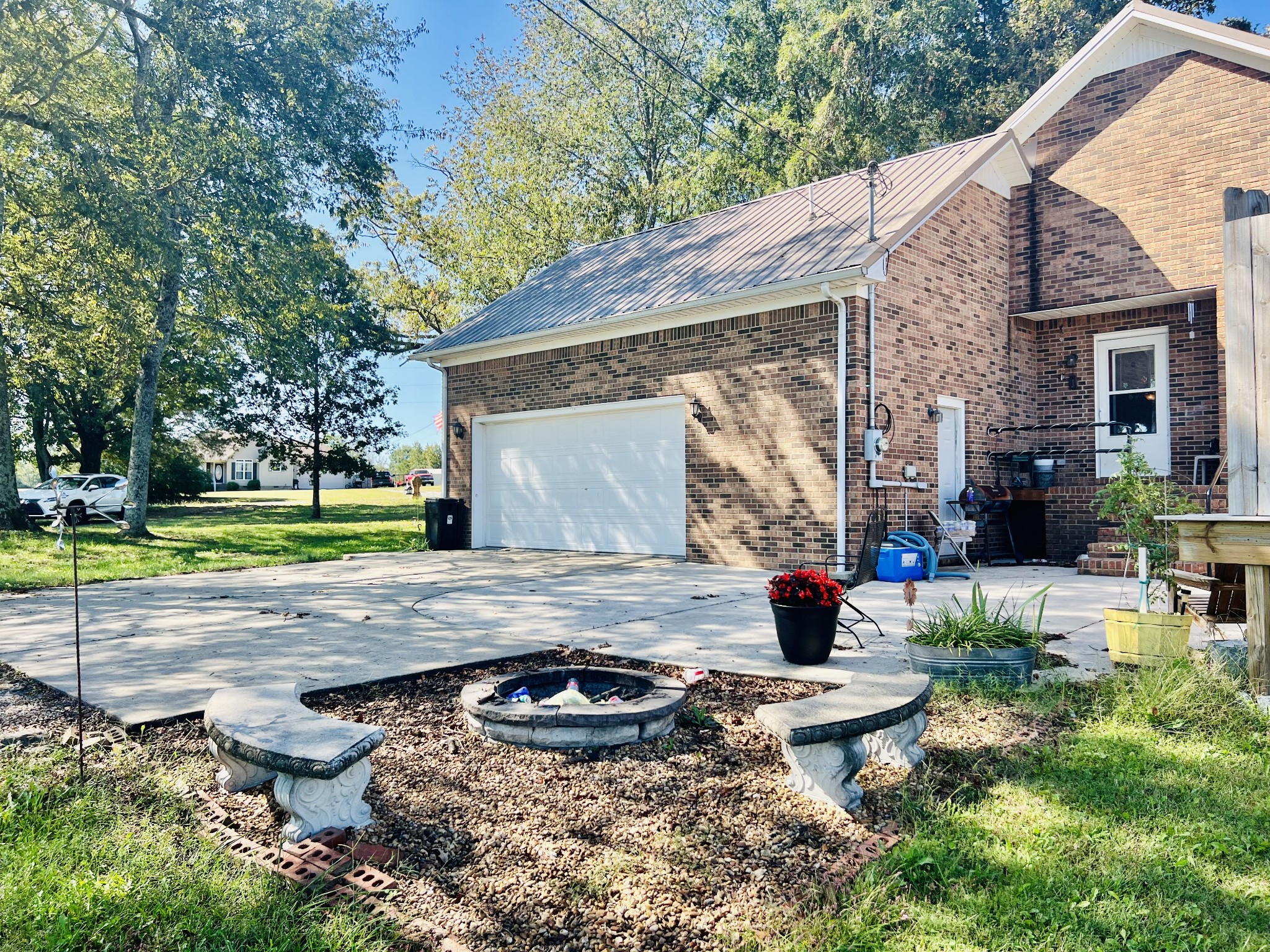 Large concrete parking area with firepit and patio area.