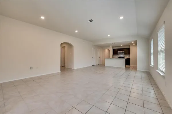 a view of empty room with furniture and a kitchen