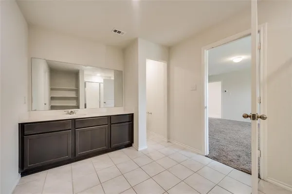 a spacious bathroom with a shower a sink and a mirror