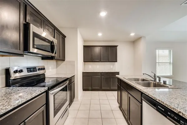 a kitchen with stainless steel appliances granite countertop a sink and a stove top oven with granite countertops
