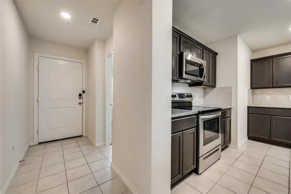 a kitchen with white cabinets a sink and stainless steel appliances