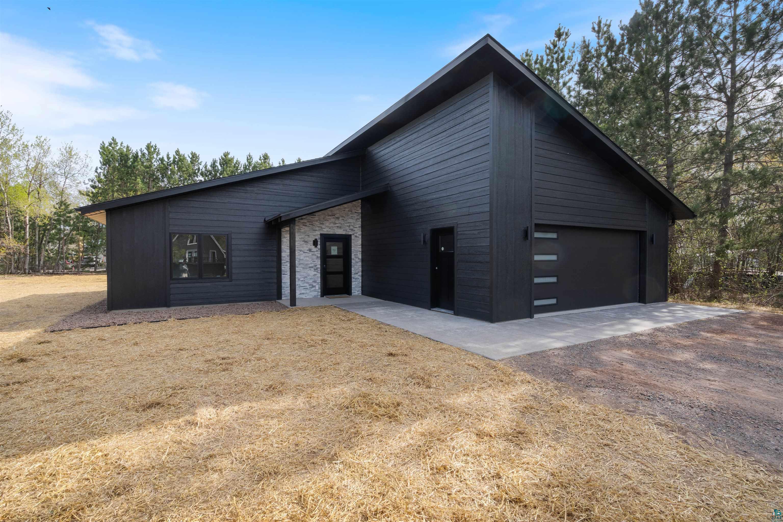 1386 Stephen Road Cloquet, MN 55720 - Photo 2 of 25 Modern architecture featuring dark horizontal siding and a light-colored stacked stone accent wall