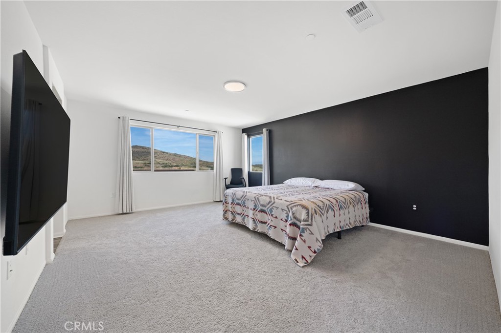 27059 Indigo Bush Road Menifee, CA 92586 - Photo 13 of 39 Primary Bedroom Featuring Accent Wall And Generous Layout