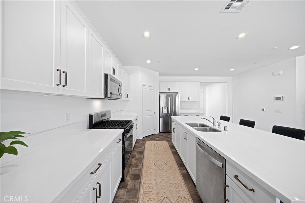 27059 Indigo Bush Road Menifee, CA 92586 - Photo 6 of 39 Modern Kitchen With White Cabinetry, Ample Counter Space, And Natural Light