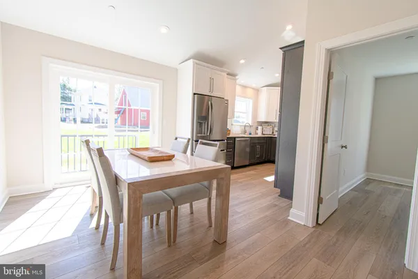 a kitchen with refrigerator and wooden floor