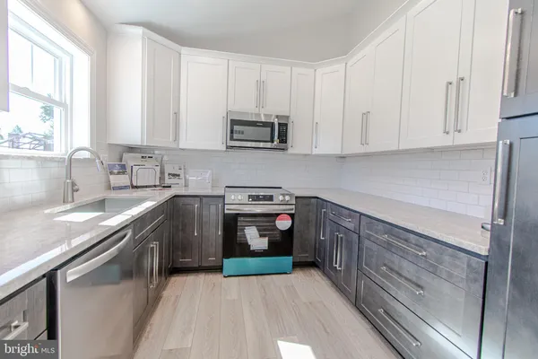 a kitchen with stainless steel appliances granite countertop a sink and a stove