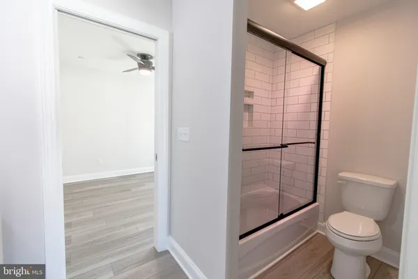 a bathroom with a granite countertop toilet and a shower